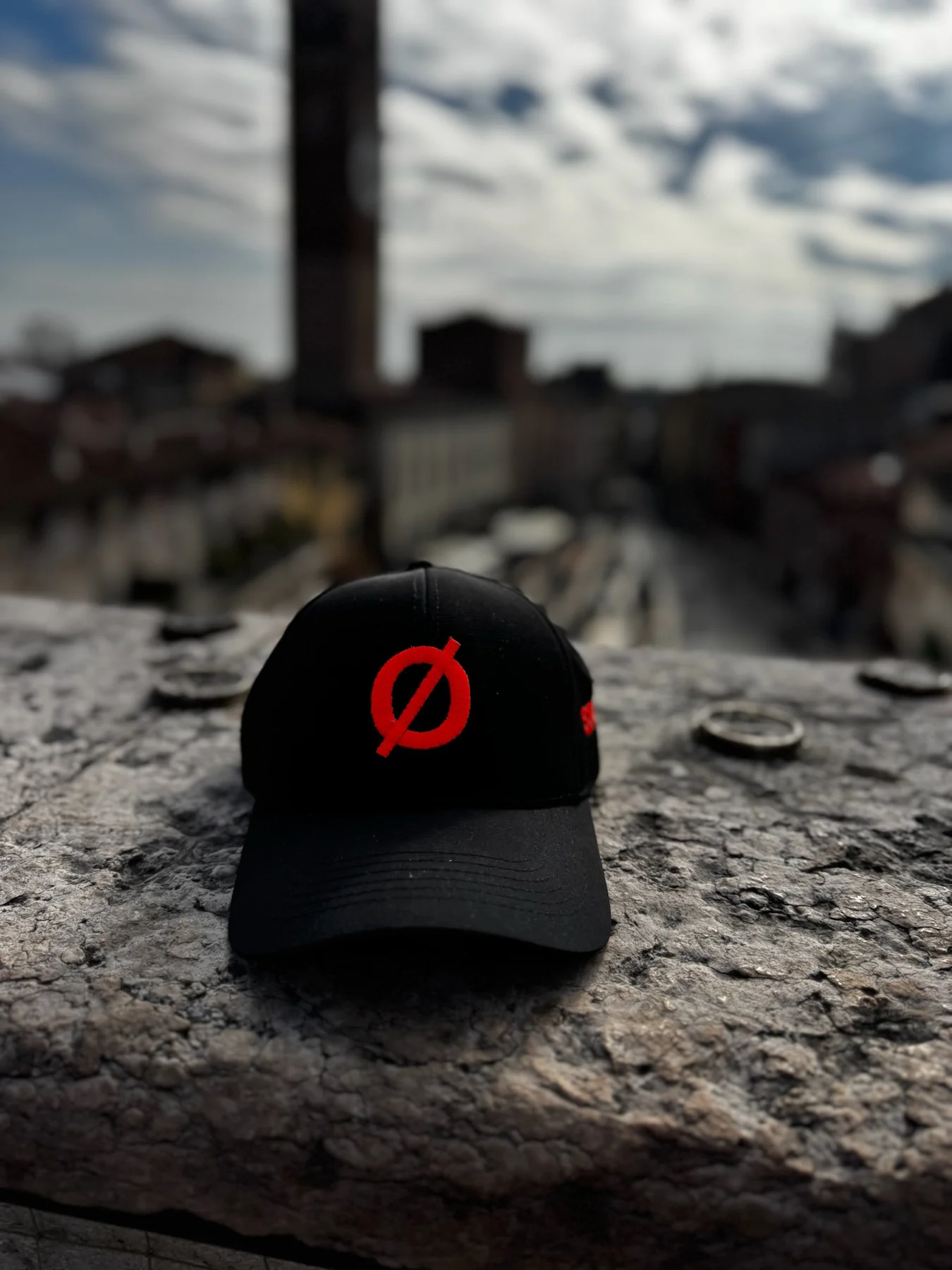 Cappellino nero con simbolo Ø rosso, fotografato in città